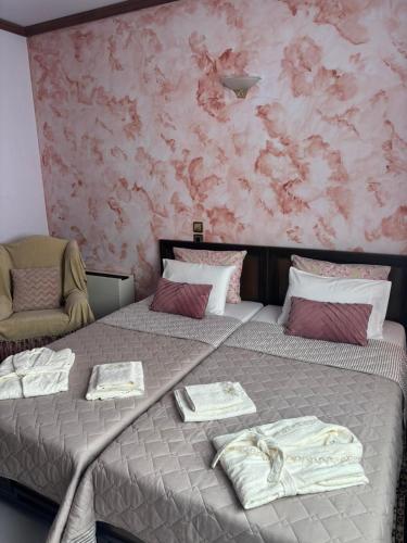 two beds in a room with a pink wall at Country Escape in Volos