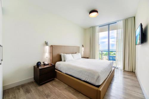 a bedroom with a bed and a large window at Direct Ocean view Condo Steps from the Beach in Hollywood
