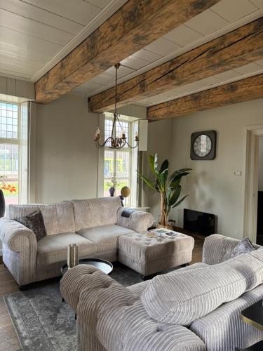 a living room with two couches and a table at B&B Het Molenhuisje Winschoten - met woonkamer & keuken in Winschoten