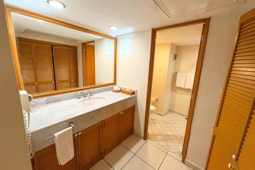 een badkamer met een wastafel en een grote spiegel bij Suite with panoramic ocean views & balcony! in Puerto Vallarta