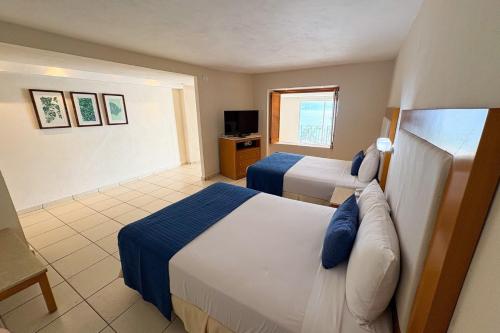 Una habitación de hotel con dos camas y un televisor. en Ocean view & direct beach access!, en Puerto Vallarta