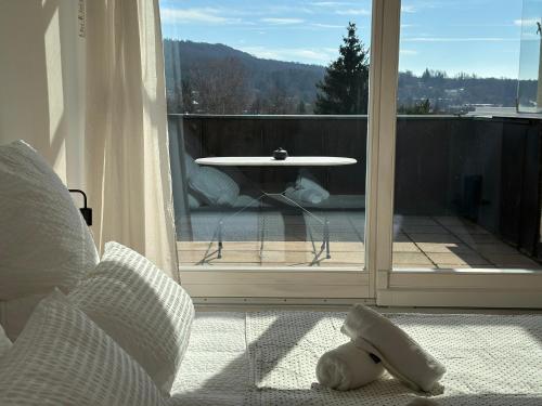 a room with a glass door with a table on a balcony at Flow Living Penthouse in See- und Bahnhofsnähe in Herrsching am Ammersee