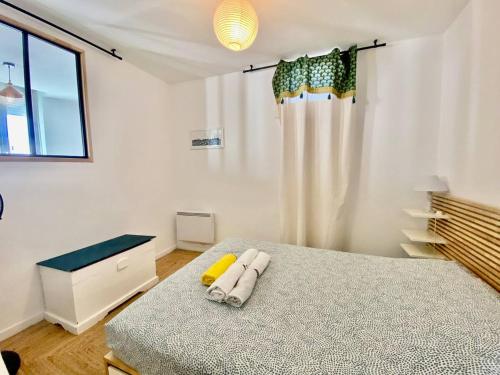 une chambre avec un lit avec deux serviettes dessus dans l'établissement Chez Maddie, à Marseille