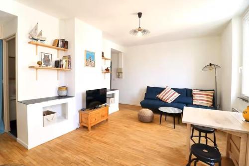 un salon avec un canapé bleu et une table dans l'établissement Chez Maddie, à Marseille