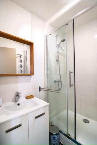une salle de bain avec un lavabo et une douche en verre dans l'établissement Chez Maddie, à Marseille