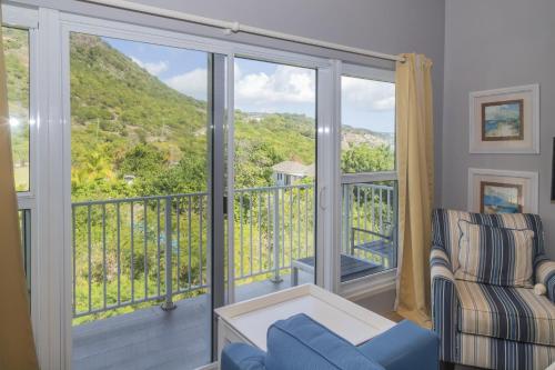 a room with a balcony with a couch and a chair at Dieppe Bay Suites in Pattersons