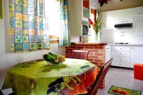 a kitchen with a table with a bowl of vegetables on it at Charmante maison à Sainte-Anne avec jardin in Sainte-Anne
