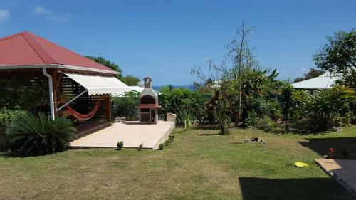 a backyard with a gazebo with a hammock on it at Charmante maison à Sainte-Anne avec jardin in Sainte-Anne