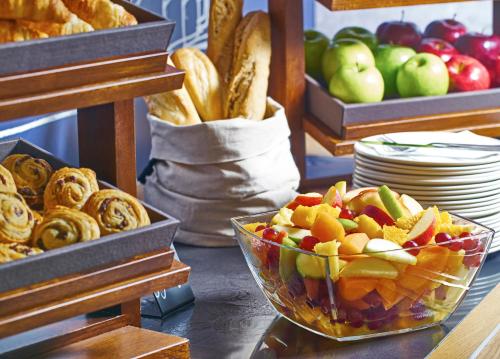 a table topped with a bowl of fruit and bread at ibis budget Manchester Salford Quays in Manchester