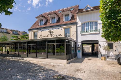 a store front of a building with windows at Le Logis d'Origine. in Marly-le-Roi