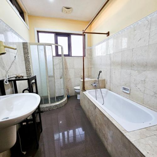 a bathroom with a tub and a sink and a toilet at Villa Djojonagoro in Ketewel