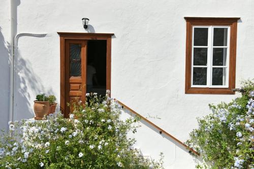 a white house with a door and a window at Serendipity Home in Hydra