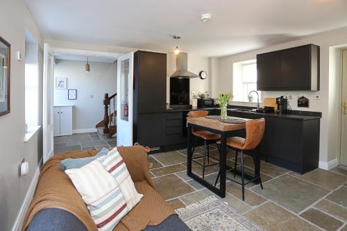 a kitchen and living room with a couch and a table at Little Priory in Lisburn