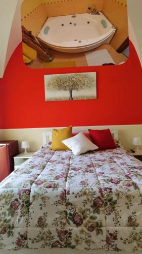 a bedroom with a bed and a bath tub on the wall at Casa San Brasi di Mariano e Lucia in Acireale