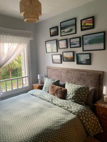 a bedroom with a bed and framed pictures on the wall at La casita de Kalani in Comillas
