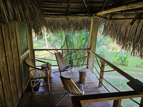 a porch of a hut with two chairs and a table at Creekside Oasis in San Felipe