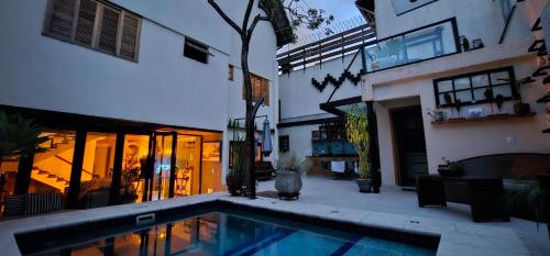 a house with a swimming pool next to a building at Pousada Chalé Poder das Pedras in Sao Paulo