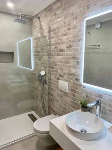 a bathroom with a sink and a toilet and a shower at Villa Mediterranea in Murter