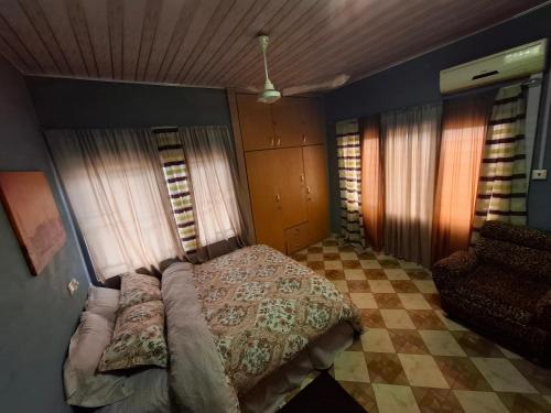 a bedroom with a bed and a checkered floor at Rankbel Holidays Apartment in Kumasi
