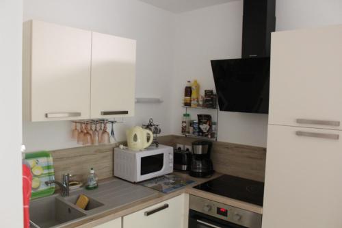 a small kitchen with a sink and a microwave at BIENVENUE EN BAIE De SOMME in Saint-Valery-sur-Somme