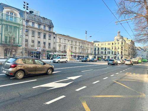 a car is driving down a busy city street at 2Rooms Apartment Universitate-Old Town in Bucharest