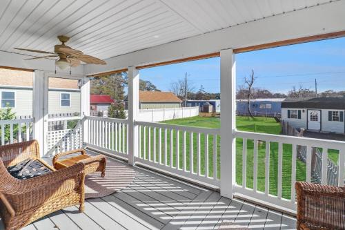 a porch with two chairs and a ceiling fan at The Sea Horse - Pet friendly with fenced yard! in Black Point Landing