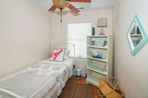 a small bedroom with a bed and a ceiling fan at The Sea Horse - Pet friendly with fenced yard! in Black Point Landing