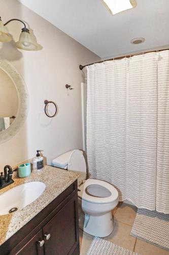 a bathroom with a toilet and a shower curtain at The Sea Horse - Pet friendly with fenced yard! in Black Point Landing
