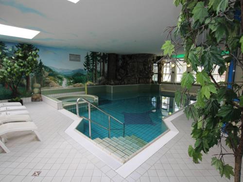 a large swimming pool in a building with at Ferienhaus an der Wiese, Tanne in Tanne