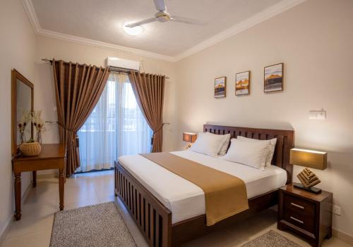 a bedroom with a large bed and a window at Marjaan Apartments in Mombasa