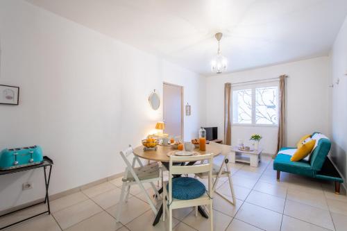 a living room with a table and a chair at Le Faubourg National Climatisé Parking gratuit Wifi in Aigues-Mortes