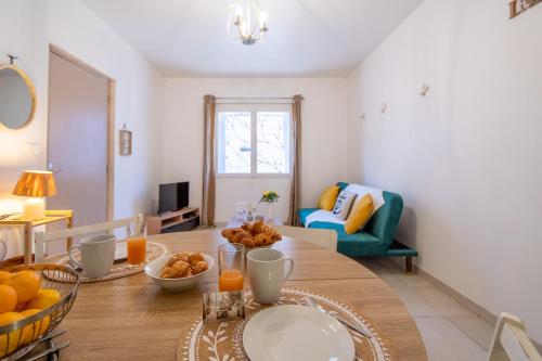 a living room with a table with oranges on it at Le Faubourg National Climatisé Parking gratuit Wifi in Aigues-Mortes