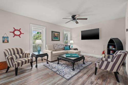 a living room with a couch and chairs and a tv at Tranquility - Brand new home in quiet location! in Deep Hole