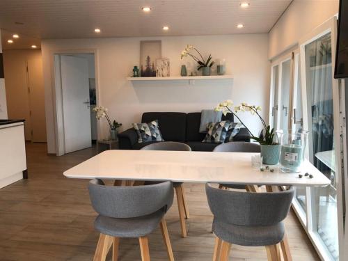 a kitchen and living room with a table and chairs at Bijou Waldeggli in Beatenberg
