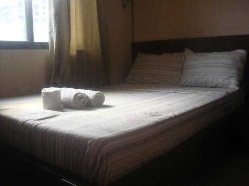 a bed with two rolls of towels on it at Hidden Pearl Hotel (Janus Luxury Suites) in Angeles