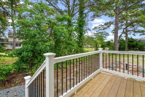 a white railing on a wooden deck with trees at Tranquility - Brand new home in quiet location! in Deep Hole