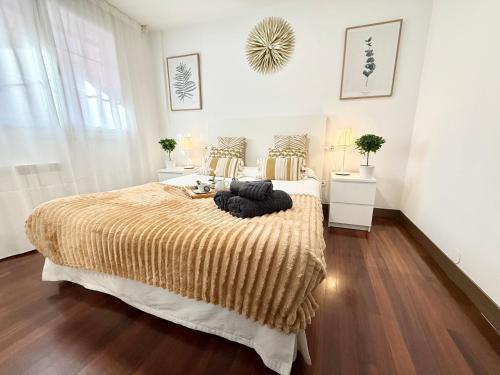 a bedroom with a large bed with a brown blanket at Castro Holidays - Céntrico Piscina Urbanización Garaje Gratis in Castro-Urdiales