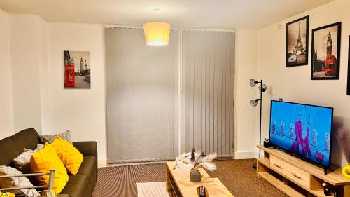 a living room with a couch and a flat screen tv at Birmingham City Centre Apartment with Parking in Birmingham