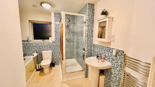 a bathroom with a sink and a toilet and a shower at Birmingham City Centre Apartment with Parking in Birmingham