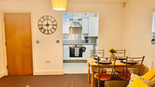 a kitchen with a table and a clock on the wall at Birmingham City Centre Apartment with Parking in Birmingham