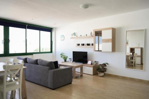 Una sala de estar con un sofá y un televisor. en CASA MACU by Mhousing, en Playa Blanca
