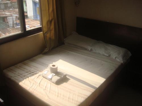 a bed with a roll of toilet paper sitting on it at Hidden Pearl Hotel (Janus Luxury Suites) in Angeles