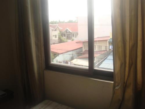 an open window with a view of a building at Hidden Pearl Hotel (Janus Luxury Suites) in Angeles