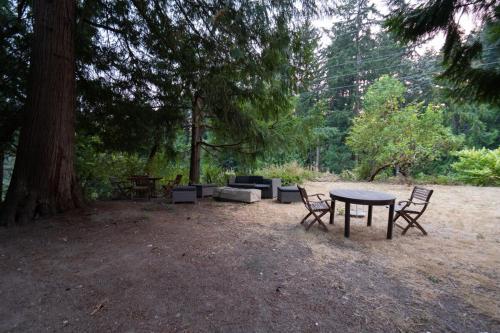 a picnic table and chairs in a park with a tree at Modern Loft with Park Like Setting View in Kirkland