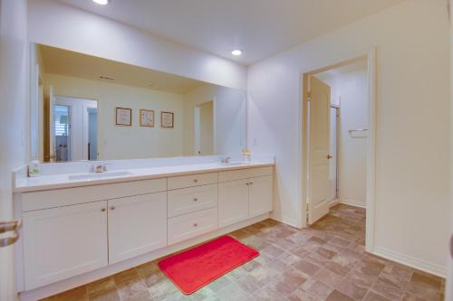 a bathroom with a large white sink and a red rug at Luxurious and Spacious Family Duplex in Menifee! in Menifee