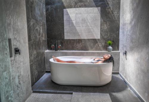 a woman laying in a bath tub in a bathroom at Hotel Esmeralda in Atlixco