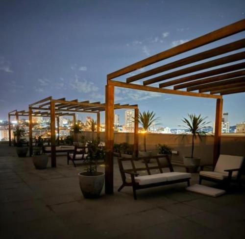 a group of benches sitting on top of a roof at Studio Carmenere Com varanda e vista incrível Mogi das Cruzes in Mogi das Cruzes