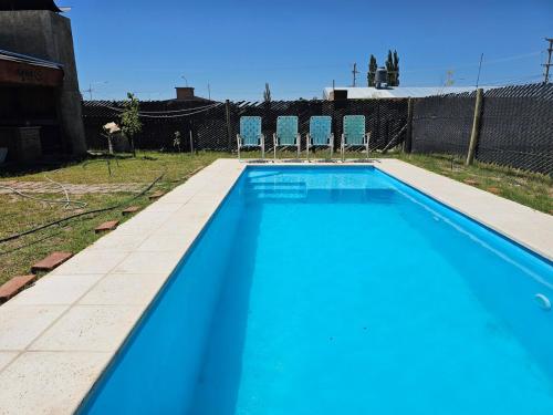 ein Swimmingpool mit blauem Wasser in einem Hof in der Unterkunft Cabaña Magus 6 personas con pileta in San Rafael