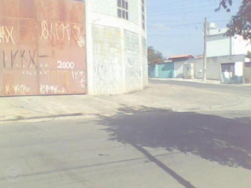 an empty street with graffiti on the side of a building at Ponto comercial, murado com grade in Itaquaquecetuba