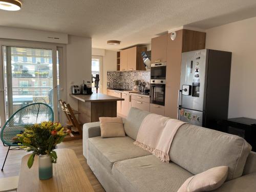 un salon avec un canapé et une cuisine dans l'établissement Port Frejus, 150 m de la plage, tres rare a la loc, à Fréjus